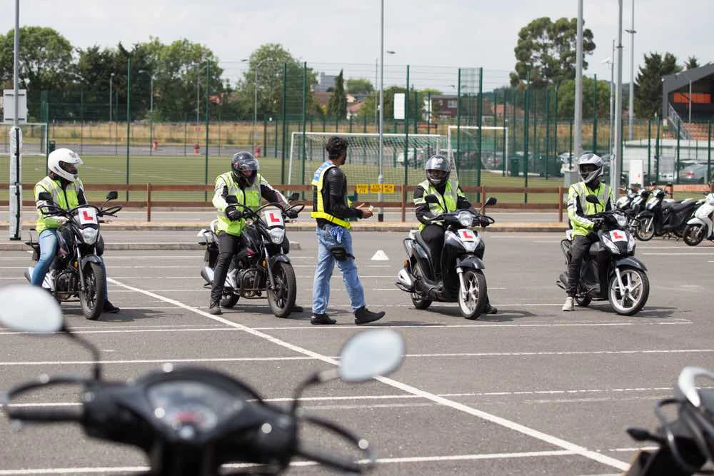 Four riders getting instruction in car park